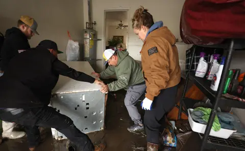 Getty Images Residents in Planada clear homes after floods