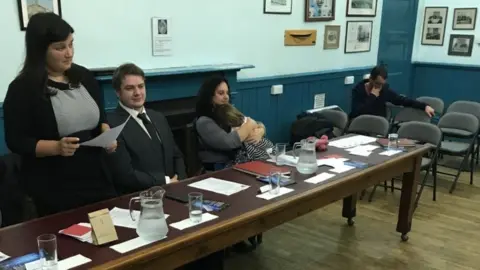 Saskia Hogbin Saskia Hogbin with her child in a council meeting