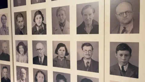 A wall with 12 pictures of people who lived through the German occupation of Jersey