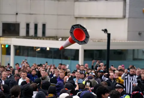 PA Media/Owen Humphreys A cone in mid-air, thrown by someone in a crowd