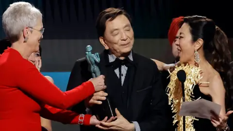 Getty Images Jamie Lee Curtis, James Hong and Michelle Yeoh accept the Outstanding Performance by a Cast in a Motion Picture award for "Everything Everywhere All at Once" onstage during the 29th Annual Screen Actors Guild Awards at Fairmont Century Plaza on February 26, 2023 in Los Angeles, California