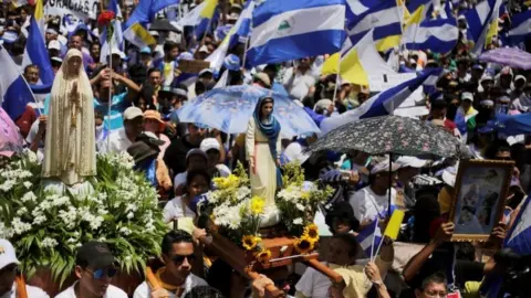 Reuters Demonstrators hold national flags during a march in support of the Catholic Church in Managua, Nicaragua July 28, 2018.