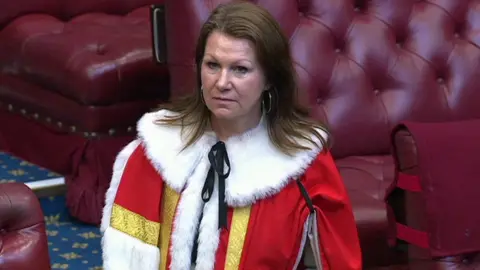 UK Parliament Baroness Hayman in the House of Lords wearing red synthetic robes