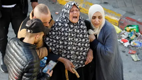 Reuters A woman reacts during a funerals of a Palestinian killed during an Israeli raid in Nablus, in the occupied West Bank (22 February 2022)