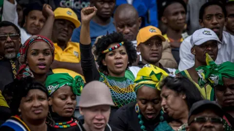 Getty Images A woman raises her fist during the funeral for Winnie Mandela held at the Orland Stadium on April 14, 2018, in Soweto, South Africa. The former wife of the late South African President Nelson Mandela, anti-apartheid campaigner Winnie Mandela, passed away on April 2, 2018 in Johannesburg, South Africa.