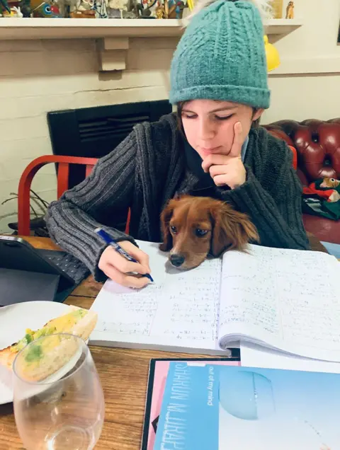 Karla Urizar Working at a desk with a dog