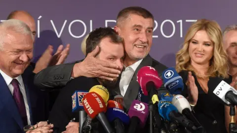 AFP Czech billionaire Andrej Babis (C,R), chairman of the ANO movement (YES) kisses Marek Prchal, PR manager of ANO for social media at ANO headquarter after Czech elections on October 21, 2017 in Prague.