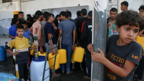 Getty Images Palestinians fill up at one of the few water stations in Khan Younis.