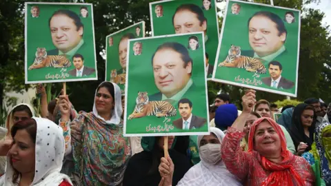 AFP Supporters of Pakistani opposition parties carry placards with the picture of ousted Pakistani Prime Minister Nawaz Sharif outside the election commission office against the alleged election rigging in Islamabad on August 8, 2018.