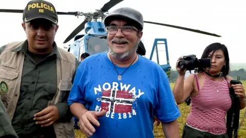 AFP FARC rebel leader Rodrigo Londono Echeverri (C), better known by his nom de guerre "Timochenko", alights from the helicopter upon his arrival at the Transitional Standardization Zone Mariana Paez, Buena Vista, Mesetas municipality, Colombia on June 26, 2017, for the final act of abandonment of arms and its end as an armed group.