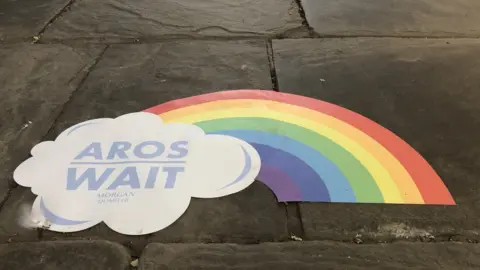 A rainbow sticker on the floor of the arcade