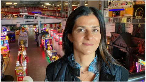 Michelle Michael faces the camera with Weston-super-Mare Pier arcade in the background.