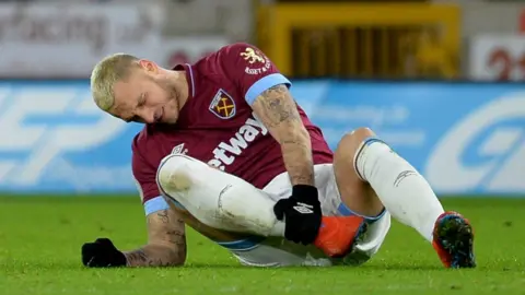 Marko Arnautovic holds his injured ankle