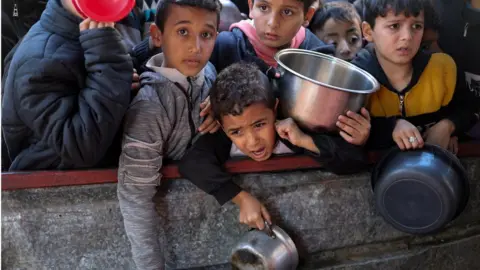 Reuters Des enfants palestiniens attendent de recevoir de la nourriture préparée par une cuisine caritative à Rafah, dans le sud de Gaza