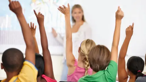 Getty Images Teacher with children in a classroom