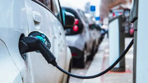 Getty Images Electric cars being charged in a street