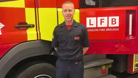 LFB Steve Moore in front of a London Fire Brigade truck
