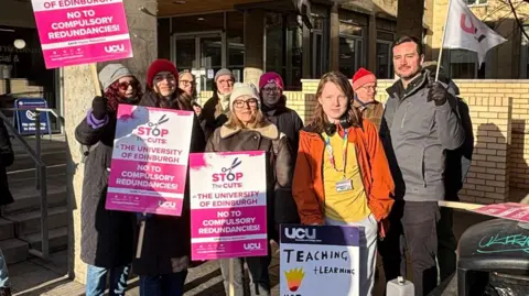 BBC UCU staff holding pink and white banners outside the University of Edinburgh on Monday.