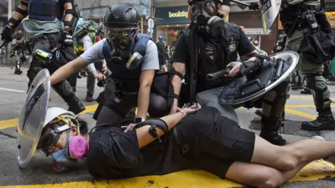 Getty Images Police hold down a detained protester in Hong Kong (1 Oct 2019)