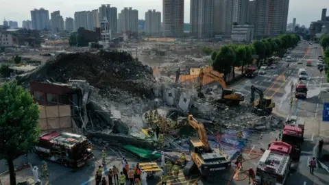 Reuters South Korean firefighters search for passengers from a bus trapped by the debris of a collapsed building in Gwangju