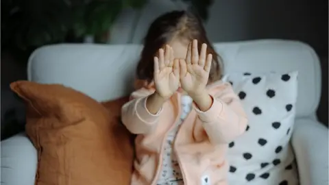 Child holding both hands up