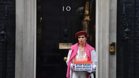 AFP Human rights advocate Bianca Jagger delivers a petition urging the UK government to halt arms sales to Saudi Arabia and to free jailed Saudi blogger Raif Badawi at 10 Downing Street in London on March 15, 2017