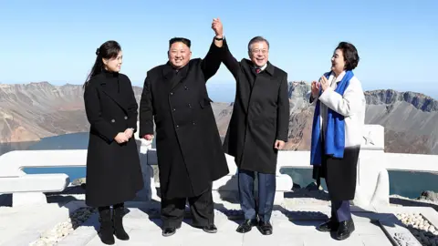 Getty Images North Korean leader Kim Jong Un (2nd L) and his wife Ri Sol Ju (L) pose with South Korean President Moon Jae-in (2nd R) and his wife Kim Jung-sook (R) on the top of Mount Paektu on September 20, 2018 in Mount Paektu, North Korea. (Photo by Pyeongyang Press Corps/Pool/Getty Images)