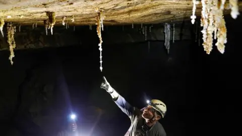 Getty Images  A caver points to salt stalactites