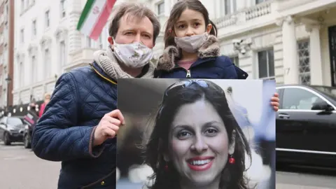 EPA Richard Ratcliffe with his daughter Gabriella during a protest outside the Iranian Embassy in London