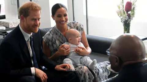 Reuters The Duke and Duchess of Sussex holding their son Archie as they meet Archbishop Desmond Tutu