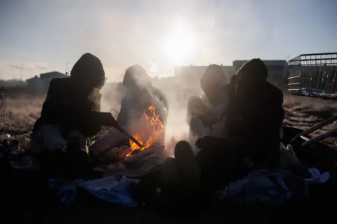 EPA A group of Ghanaian people prepare a bonfire in Medyka, Poland's border with Ukraine, five days after the start of Russia's attacks on Ukraine, March 1, 2022, in Medyka, Poland. Poland has become a safe haven for thousands of people fleeing the war that Russia launched against Ukraine on February 24. This country, which borders with Ukraine, is being used by refugees in order to escape from the war that is taking place in their country. The war in Ukraine, for the moment, has resulted in 352 civilian deaths and more than 2,000 wounded, of which 16 minors have lost their lives and 45 are wounded.