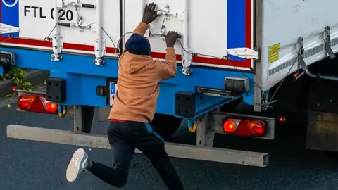 Getty Images man tries to climb on lorry