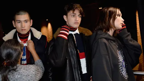 Getty Images Anwar Hadid (centre) with sister Bella and another male model