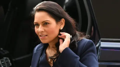 PA Media Home Secretary Priti Patel arrives at the National Police Chiefs" Council and Association of Police and Crime Commissioners joint summit, at the Queen Elizabeth II Conference Centre, in London.