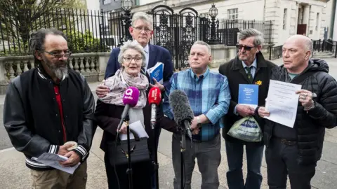 PA Kate McCausland with victims and families of victims of historical institutional abuse outside Belfast's Laganside Courts