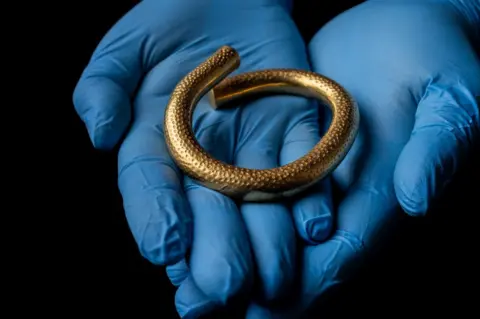 Tom Kay The arm ring being held in someone's hands