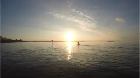Matt Vickery Paddling into the sunset: This idylic scene was taken by Matt Vickery at Llanfairfechan, with Puffin Island and Anglesey in the background