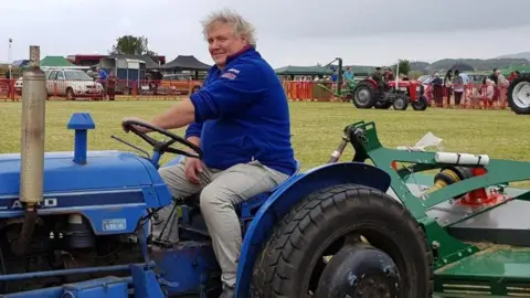 CJS Photography A man in a blue jumper sitting on a blue tractor-style vehicle