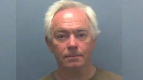 A mugshot of Angus Blackmore - an elderly man with white hair.