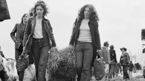 Getty Images / Reg Burkett Festival-goers used hay to build rain shelters