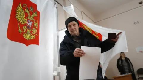 Man leaves voting booth in Sovyaki, Russia, on 18 March 2018