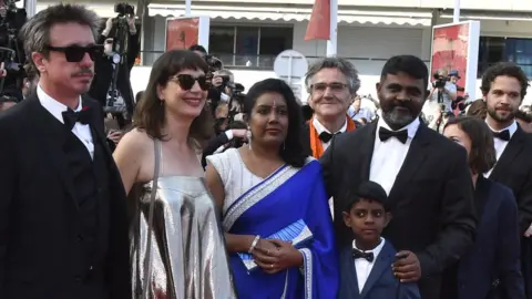 Jude Ratnam Jude Ratnam with his family and the Demons in Paradise production team at the Cannes film festival