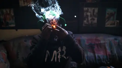 BBC/SHIRAAZ MOHAMED An unknown man smokes mandrax, a sedative crushed and smoked in a broken bottle head mixed with marijuana in the derelict San Jose building in Johannesburg, South Africa