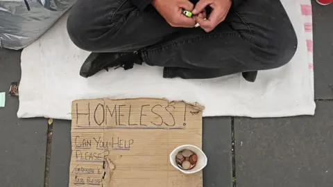 Getty Images Homeless person with sign