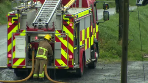 A firefighter working at a fire engine