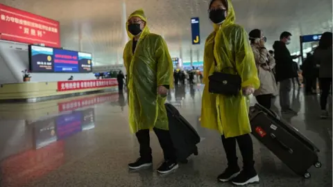 HECTOR RETAMAL Passengers wearing protective gear walk at the Tianhe Airport after it was reopened today, in Wuhan in China's central Hubei province on April 8, 2020.