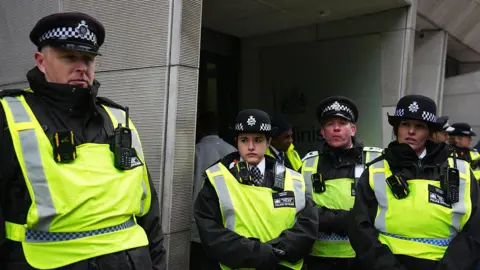 Getty Images Police outside the MoJ building in London during a protest in November 2025