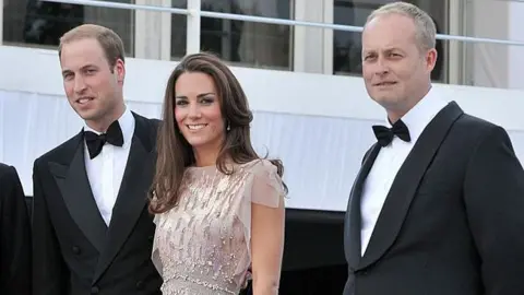 Getty Images The financier and Prince William are wearing dinner jackets and Catherine, Princess of Wales a sleeveless dress.