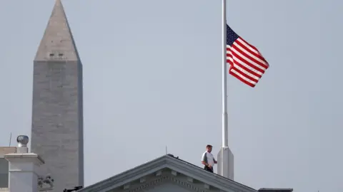 Reuters A worker lowers the flag over the White House in Washington to half-staff