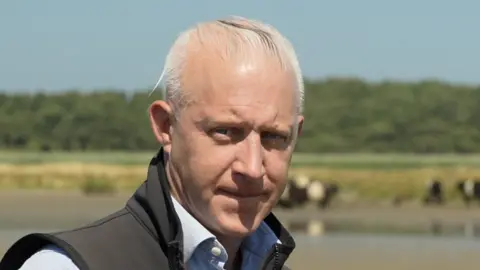 Jamie Niblock/BBC Jake Fiennes, the director of Holkham National Nature Reserve in north Norfolk, outside on the estate on a clear and sunny day